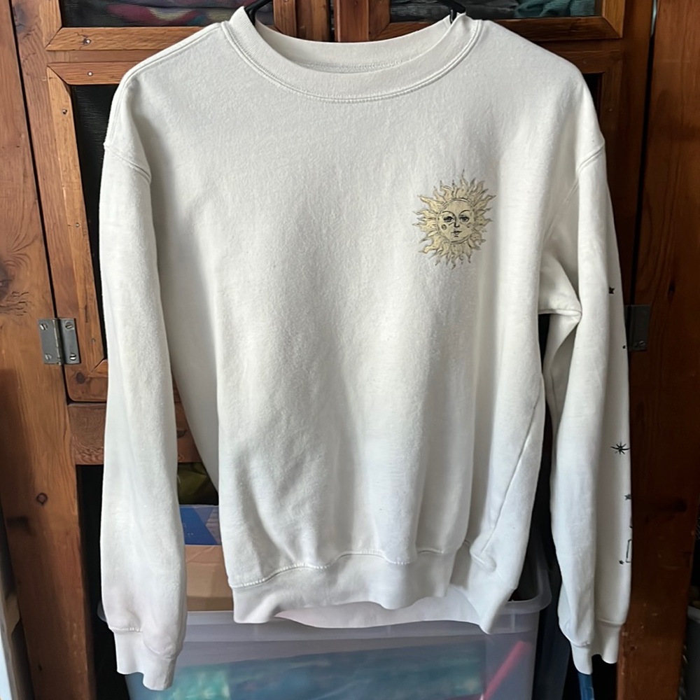 Cream colored sweater, design is the sun with radiate love